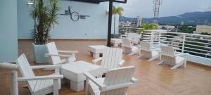 a group of white chairs and tables on a balcony at New Kingston Condo Apt in Kingston