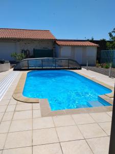 a large blue swimming pool in front of a house at Le Jardin de Gobelyne in Drain