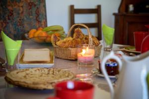 a table with bread and a candle and a basket of food at Le Jardin de Gobelyne in Drain