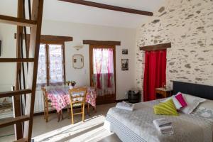 a bedroom with a bed and a table and chairs at Le Jardin de Gobelyne in Drain
