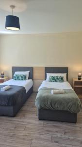 a bedroom with two beds and two tables at Large two bedroom apartment Athlone in Athlone +1 photo
