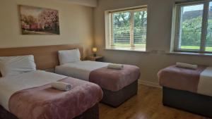 a hotel room with two beds and two ottomans at Large two bedroom apartment Athlone in Athlone