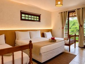 a bedroom with two beds and a window at EstrelaMar Boutique in Búzios