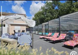 a group of chairs sitting in a patio at Maison piscine chauffée in Puybegon
