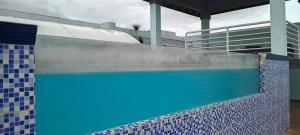a swimming pool with a blue tiled wall next to a building at New Kingston Condo Apt in Kingston
