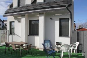 a patio with chairs and a table on a house at Polanki10 Łebski Dworek u Anity in Nowęcin