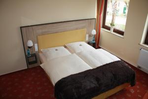 グレートジールにあるHotel Zum Alten Sielのベッドルーム(白いシーツを使用した大型ベッド1台付)