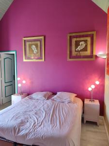 a bedroom with a pink wall and a bed at Chez Herveline Le Fer - Chambres et table d'hôtes in Plouigneau