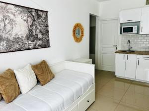 a living room with a white couch and a kitchen at Chic & Cosy in Antibes