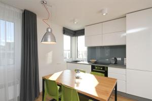 a kitchen with a wooden table and green chairs at Polanki10 Łebski Dworek u Anity in Nowęcin