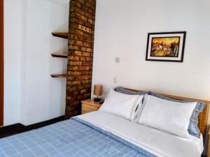 a bedroom with a bed and a brick wall at Yoly's House in Caraz