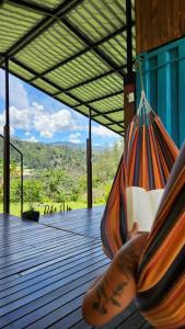 a person sitting in a hammock on a deck at Kolibri Containers Boyacá in Guayatá