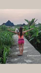 a woman walking down a path with her arms out at CalmNest Lagos in Ikorodu