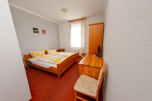 a bedroom with two beds and a table and a chair at Aparthaus Schmiedeschenke in Dresden