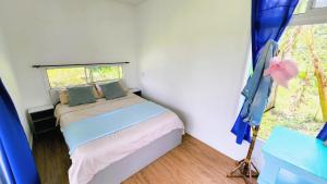 a small bedroom with a bed and a window at Kolibri Containers Boyacá in Guayatá