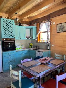 a kitchen with a wooden table and blue cabinets at Chalet F&V Radosavović in Žabljak