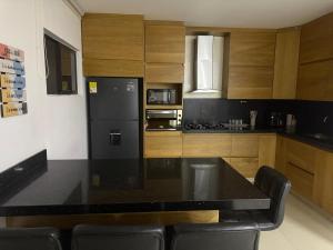 a kitchen with a black counter top and wooden cabinets at Lumière House in Medellín