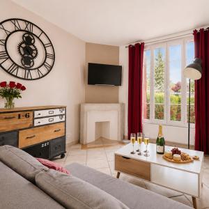 a living room with a couch and a clock on the wall at T3 lumineux, central, parking & confort moderne in Saint-Cyr-lʼÉcole