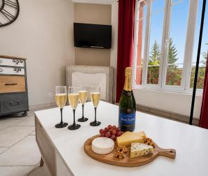 a table with three glasses of champagne and cheese at T3 lumineux, central, parking & confort moderne in Saint-Cyr-lʼÉcole
