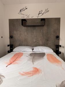 a bed with feathers on it in a bedroom at mobil home spacieux climatisé sur camping sol a gogo in Saint-Hilaire-de-Riez +16 photos