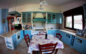 a kitchen with blue cabinets and a table with chairs at Il Veliero E I Girasoli in Taureana