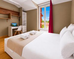 a bedroom with a large white bed and a desk at T3 lumineux, central, parking & confort moderne in Saint-Cyr-lʼÉcole
