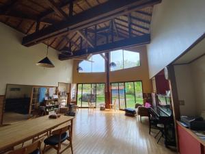a large living room with large windows and wooden floors at ロッジ星の時間 Lodge in Hokuto