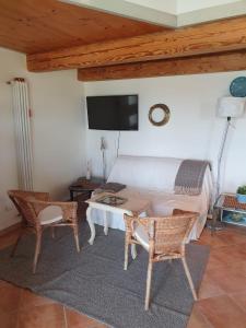 a bedroom with a bed and a table and chairs at La Cassetta Rossa in Corinaldo