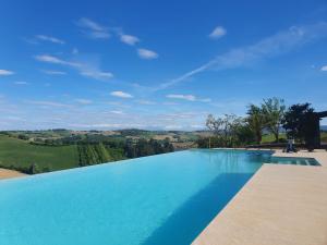a large swimming pool with a view of the countryside at La Cassetta Rossa in Corinaldo