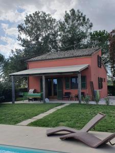 a small pink house with a swimming pool in front of it at La Cassetta Rossa in Corinaldo
