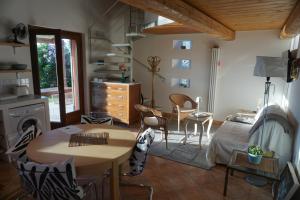 a living room with a table and a bedroom at La Cassetta Rossa in Corinaldo