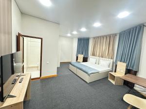 a hotel room with a bed and a television at Center Hotel Darhan in Tashkent