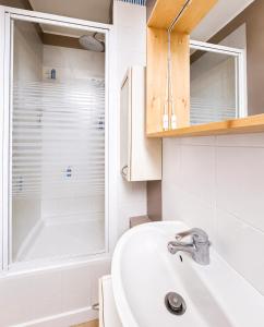 a bathroom with a sink and a shower at T3 lumineux, central, parking & confort moderne in Saint-Cyr-lʼÉcole +25 photos