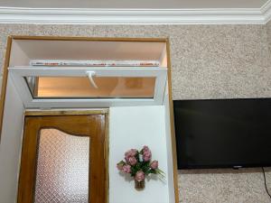 a door in a room with a mirror and flowers at Guest House koshki in Iprari