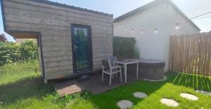 a patio with a table and chairs in a yard at Maisonnette des trois frontières in Richwiller