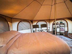 a large tent with a bed in a room at Mesa Verde Tent in Farmington