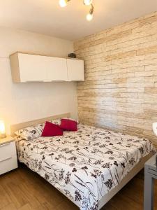 a bedroom with a bed with two red pillows at Apartment Vrančić in Šibenik