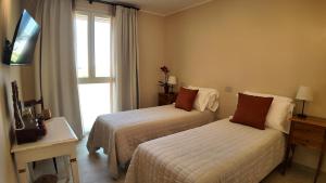 a hotel room with two beds and a window at Agriturismo Ca' Brusca in Due Maestà