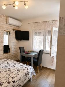 a bedroom with a desk and a bed and a table at Apartment Vrančić in Šibenik