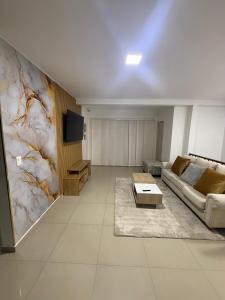 a living room with a couch and a tv at Lumière House in Medellín