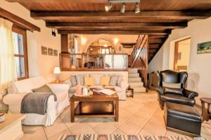 a living room with a white couch and a table at Fyllosia Villa Part of Cretan Retreat in Archanes