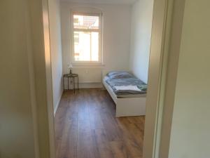a small room with a bed and a window at Arnold Apartments in Glauchau