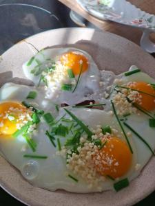 a plate of eggs with sesame seeds and green onions at Gîte, Le Séchoir à Lin demeure de charme in Veauville-les-Baons