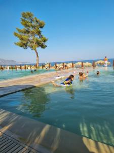 a group of people in the water at a beach at Calma4 in Agioi Theodoroi