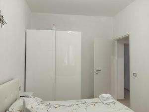 a white bedroom with a large mirror and a bed at Oasi nel cuore di Noto in Noto +6 photos