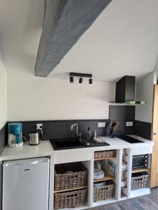 a kitchen with a sink and a counter top at Gîte, Le Séchoir à Lin demeure de charme in Veauville-les-Baons +15 photos