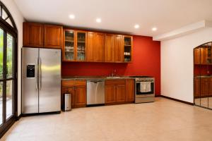 a kitchen with wooden cabinets and stainless steel appliances at Villa Sulterra in Tambor