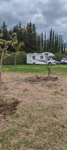 a white trailer parked in a field with a car at Villa Cilento Parking e Sosta Camper in Capaccio-Paestum