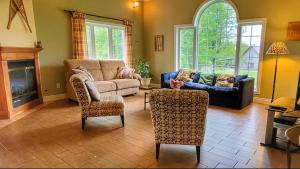 a living room with a couch and a chair at Domaine des sentiers in Mansonville