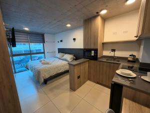 a kitchen and a bedroom with a bed in a room at Hoteles JMC in Antofagasta